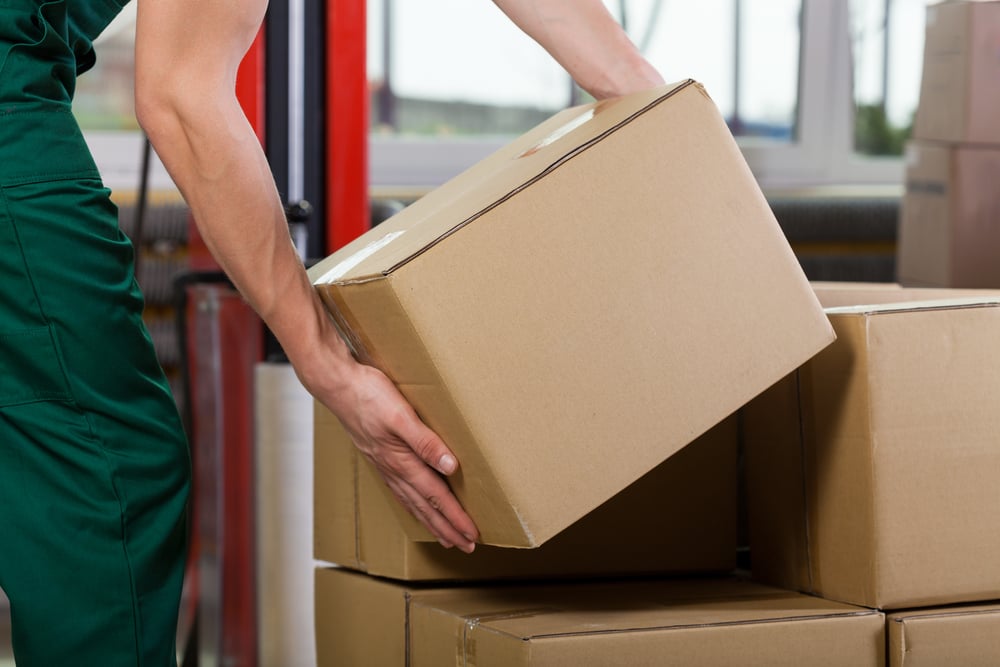 Hands of warehouse worker lifting box, horizontal Hands of warehouse worker lifting box, horizontal